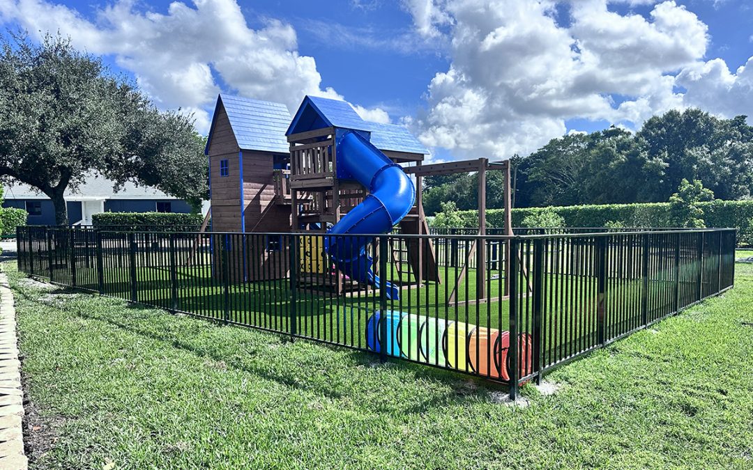 Black aluminum fence installed around a backyard playground in Davie, Broward County, Florida, by Atanda Fence of South Florida.