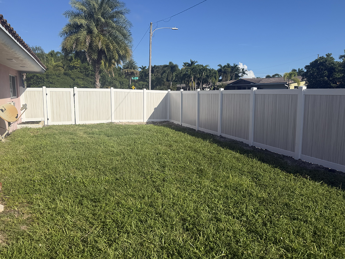 Two-tone Aspen PVC privacy fence enclosing a residential backyard in Oakland Park, Broward County, Florida.